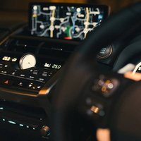 夜間走行中の運転席のカーナビとハンドル周辺の写真