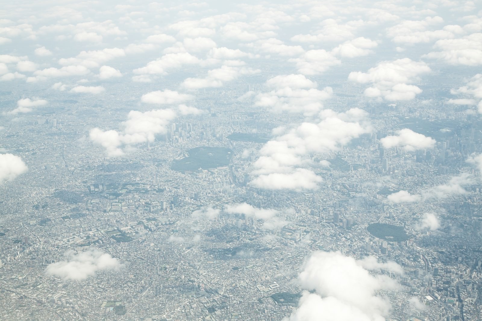 雲の上から撮影した東京の都市風景、白い雲が浮かぶ上空から見下ろした街並み