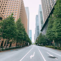 丸の内エリアの高層ビル群と白線が引かれた直線道路の写真