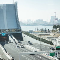 東京港トンネル入り口と湾岸線の高架道路を走行する車両の写真