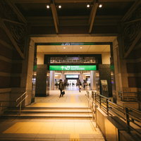 夜間のJR東京駅丸の内北口改札前の通路と駅利用者の流動の写真