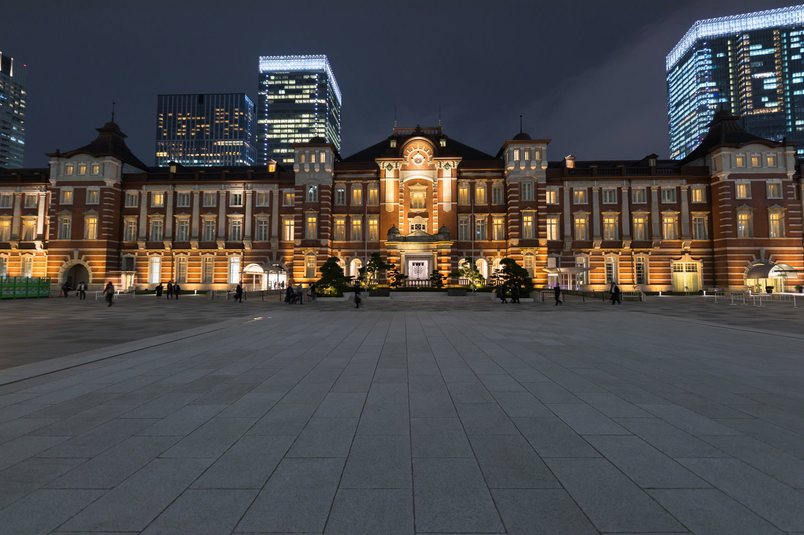 ライトアップされた東京駅の赤レンガ駅舎と背景の高層ビル群