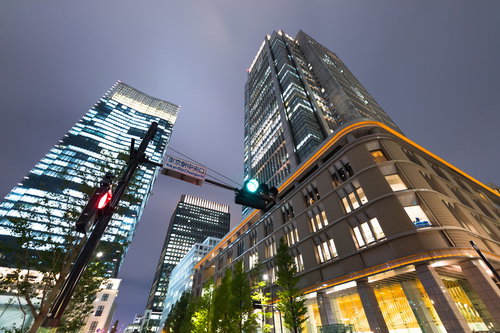 東京駅中央口前のビル群と夜景、信号機と街路樹