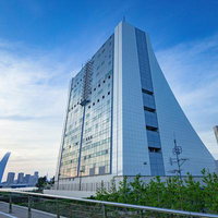 東京港トンネルの換気所に映る夕焼けと都市風景の写真