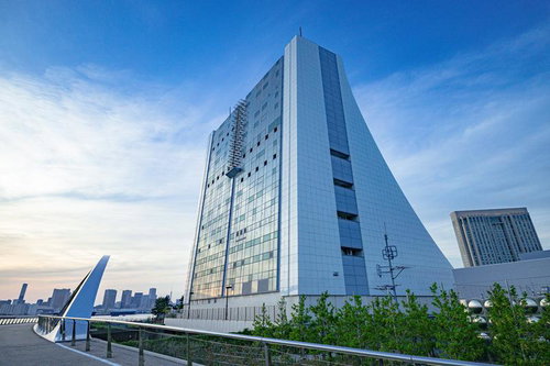 東京港トンネルの換気所に映る夕焼けと都市風景