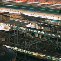 駅ホームを通過する緑色の電車が走る駅構内のの写真