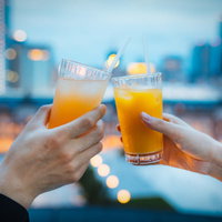 夜景を眺めながら乾杯するカップルのロマンチックなデートの写真