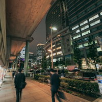 会社員の後ろ姿と丸の内の高層ビル群の夜景の写真
