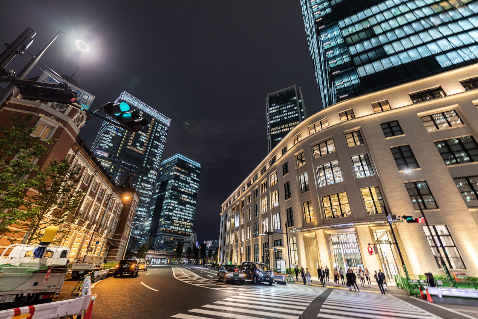 夜の丸の内ビル群と横断歩道、車道が写った東京駅周辺の夜景