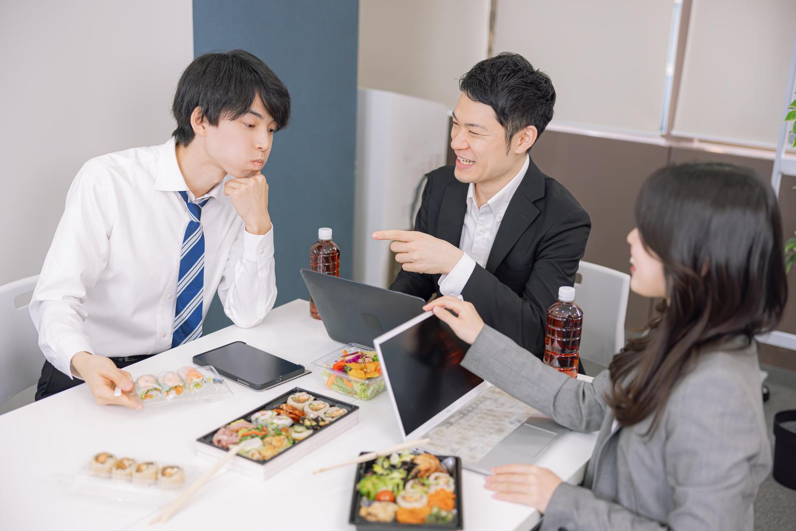 オフィスでランチミーティングをしながら弁当を食べるビジネスパーソン［モデル：たくみ 吉屋ゆり モデルリリース］