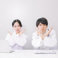 医師たちが示す禁止のジェスチャーと医療現場での警告表現の写真