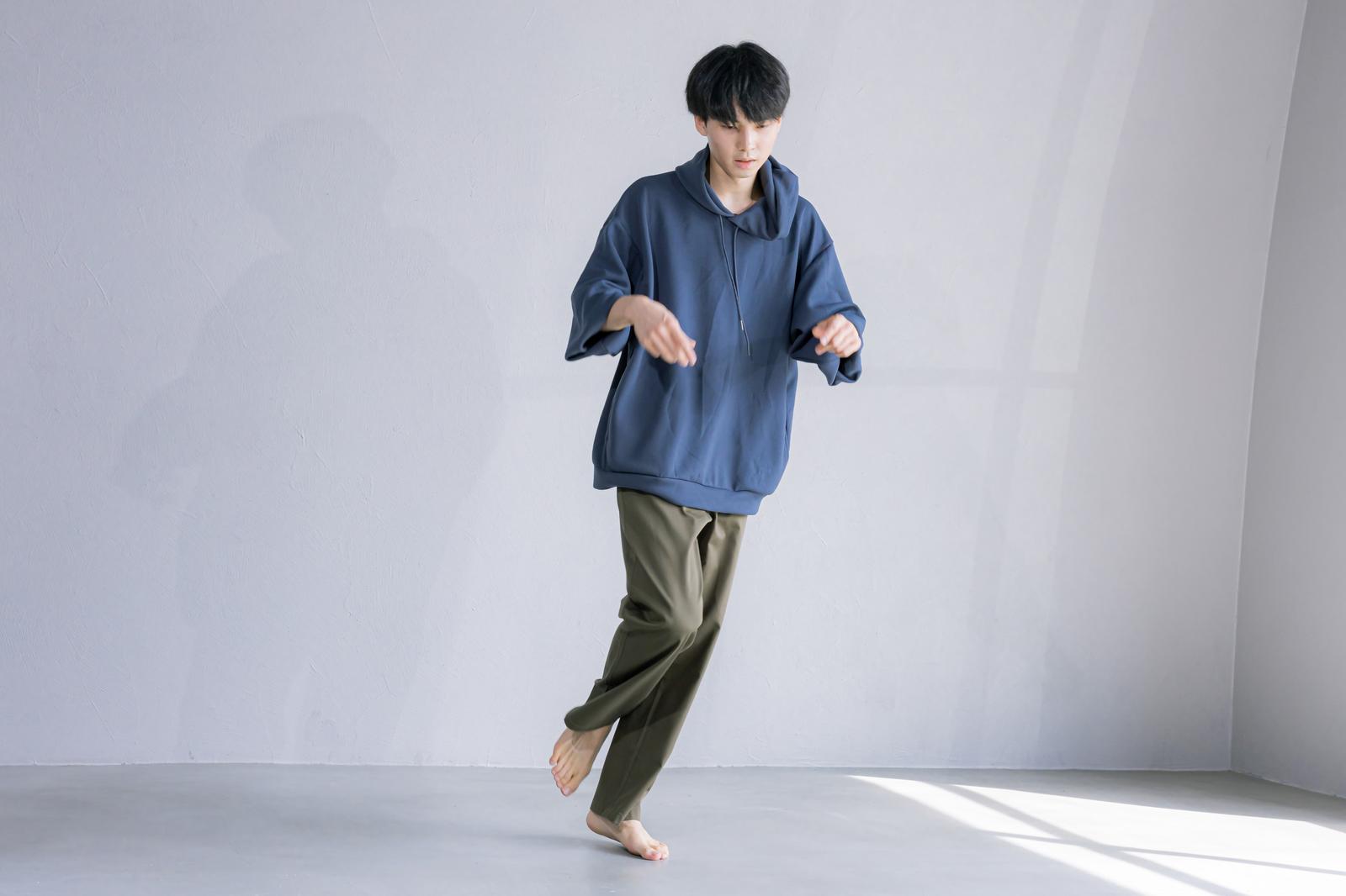 紺色のパーカーを着た男性が片足を浮かせてダンスポーズをしている［モデル：たくみ］