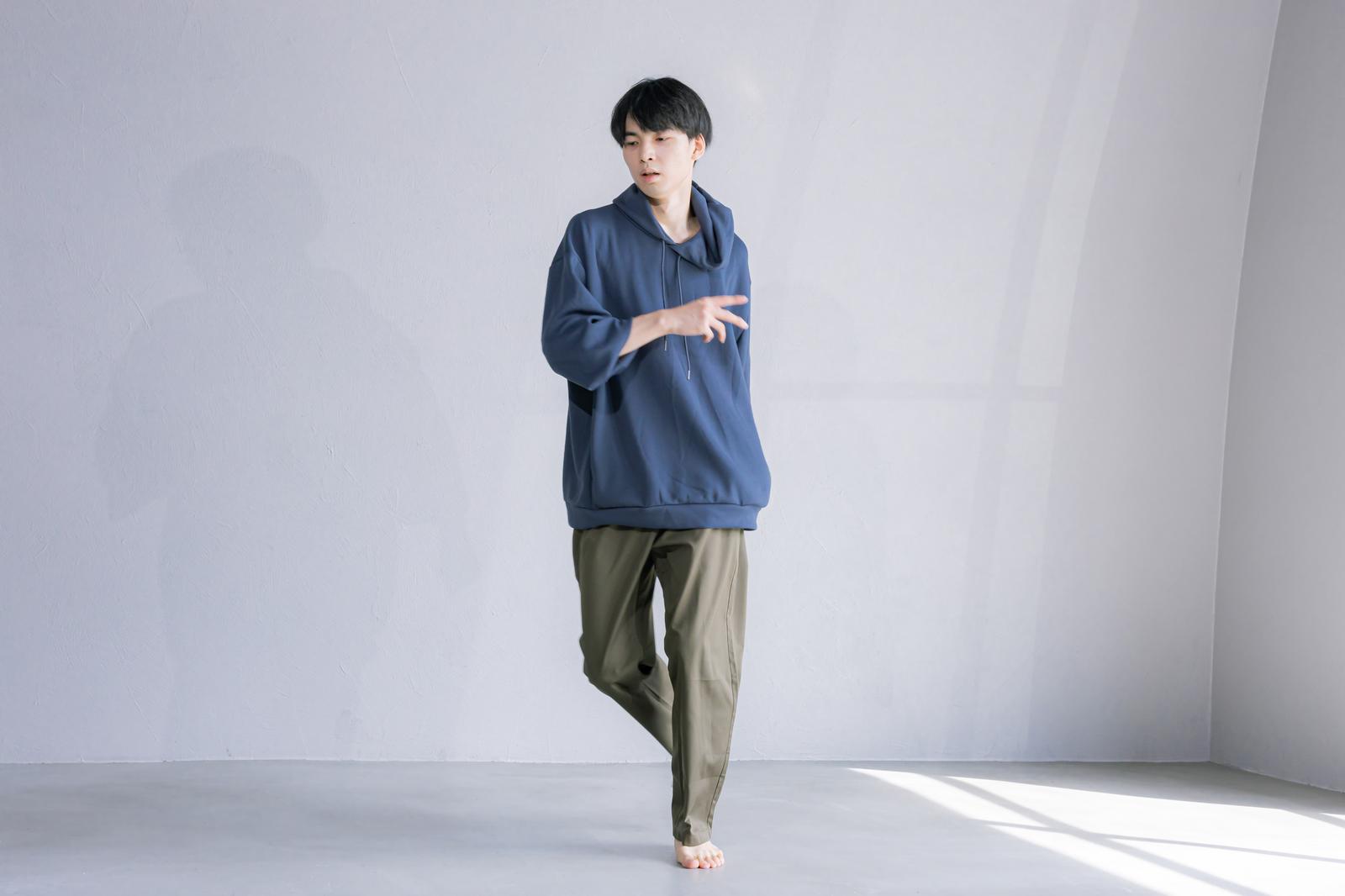 青いパーカーを着た男性がダンスポーズをしている［モデル：たくみ］