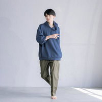 青いパーカーとカーキ色のパンツを着た男性のダンスポーズの写真