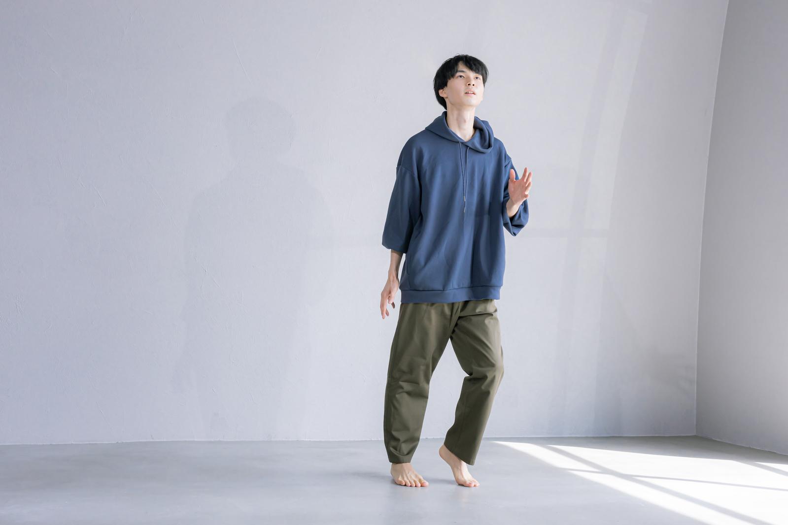 紺色パーカーを着た男性が片足を上げてダンスするポーズ［モデル：たくみ］