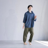 紺色パーカーとカーキパンツで片足を持ち上げてダンスする男性の写真