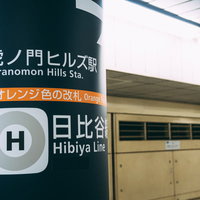 日比谷線虎ノ門ヒルズ駅のホームに立つ白い柱と駅名表示の写真