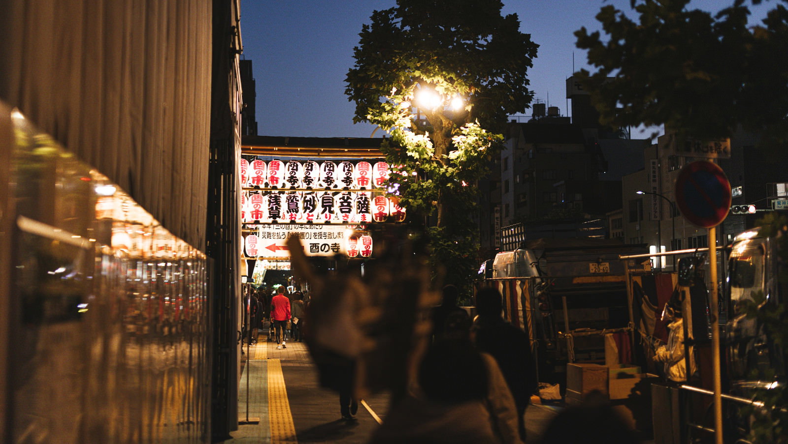 提灯の明かりに照らされた酉の市の夜の参道風景