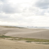 遠景に日本海を望む鳥取砂丘の写真