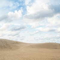 青空に浮かぶ白い雲と鳥取砂丘の風景の写真
