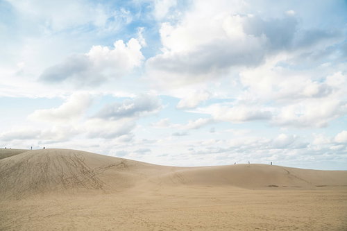青空に浮かぶ白い雲と鳥取砂丘の風景