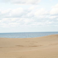 鳥取砂丘から拝む水平線と青い海・雄大な自然風景の写真
