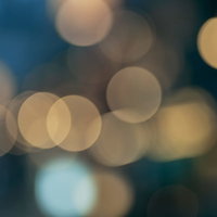 暗闇から浮かび上がる温かい光の煌めきと丸ボケの写真