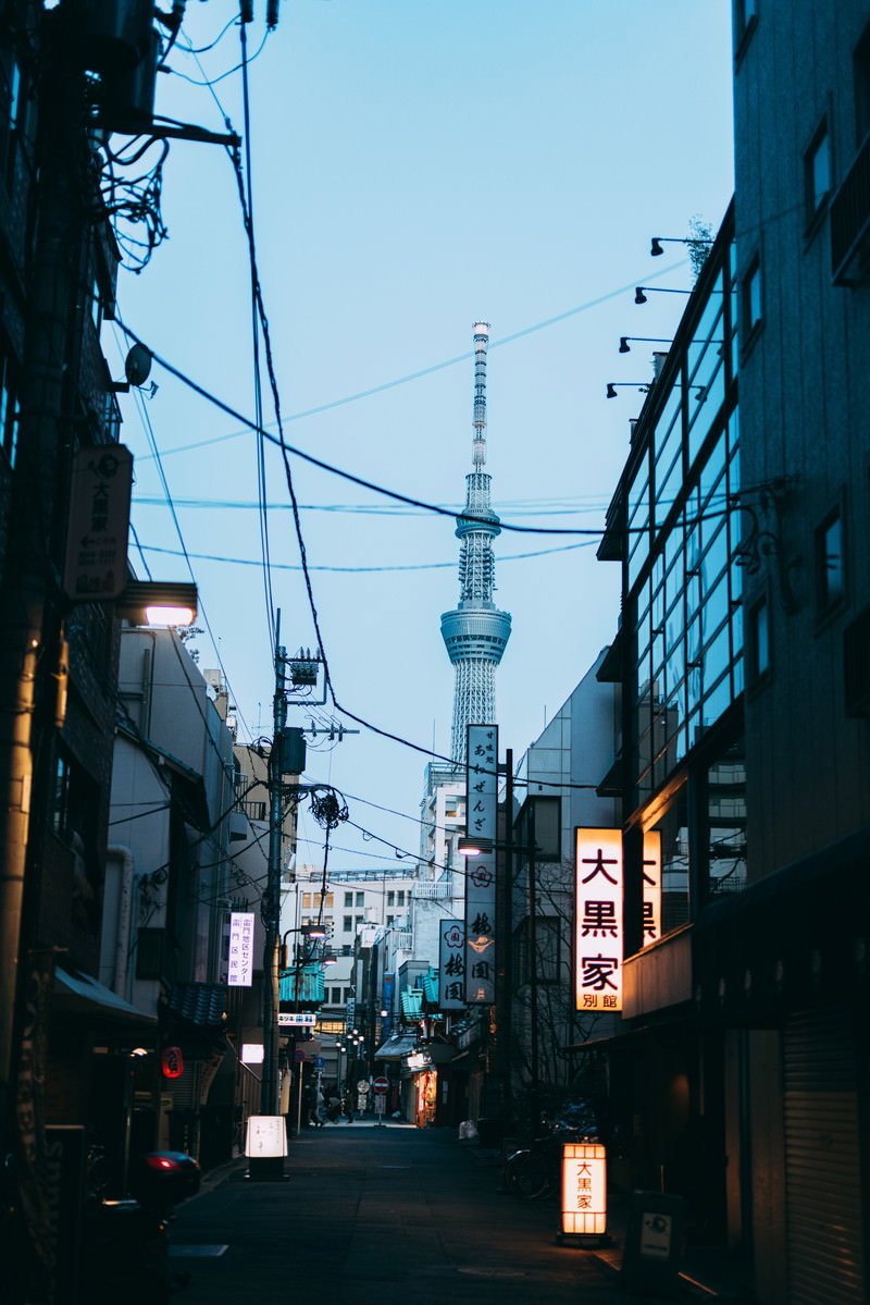 浅草の商店街の路地裏から見上げた東京スカイツリーと夕暮れの街並み