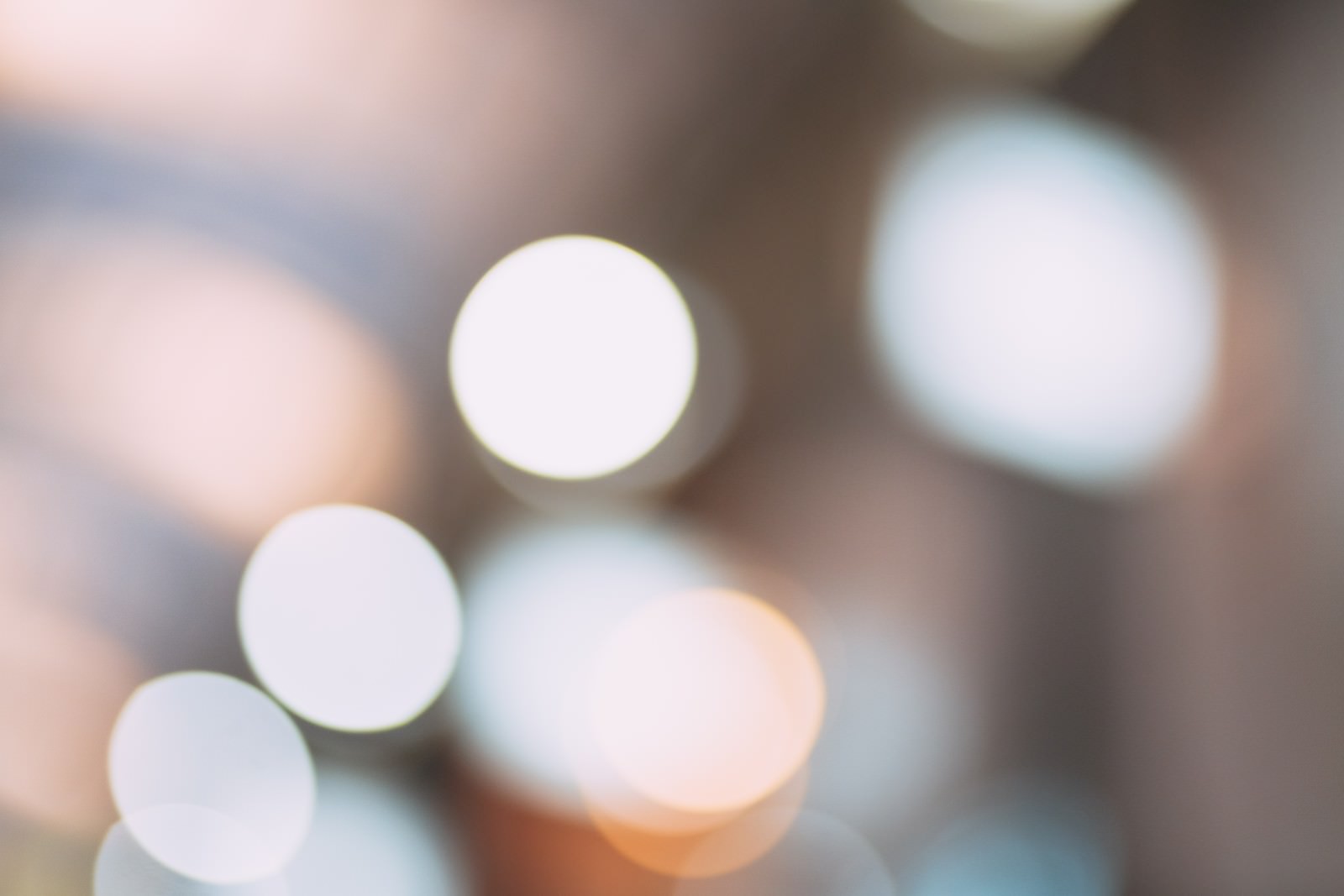 暖色系の光が円形にぼけてキラキラと煌めく抽象的な背景