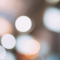 暖色系の光が円形に広がるボケと玉ボケの背景の写真