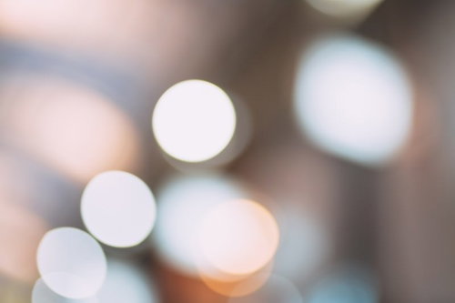暖色系の光が円形に広がるボケと玉ボケの背景