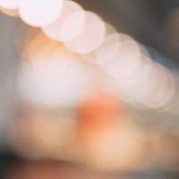 暖色系のオレンジ色の光が重なり合った一面の玉ボケの写真