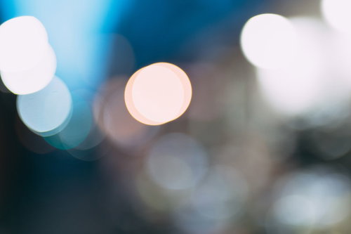 青い背景に浮かぶ玉ボケ。白く輝く光の煌めき