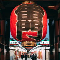 雷門越しに見る仲見世通りと浅草寺境内の参詣客の写真