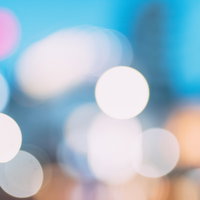 青色の背景に浮かぶ光の玉ボケの写真