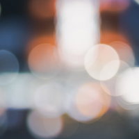 重なり合うオレンジと白の玉ボケ、煌めく光のテクスチャーの写真