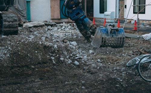 重機周辺に積み上げられた工事現場の瓦礫と土砂