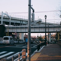 歩道から見た車道と高架鉄道が重なる都市風景の写真