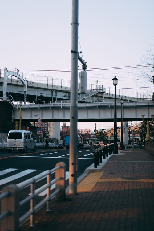 歩道から見た車道と高架鉄道が重なる都市風景