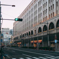 青信号の車道と横断歩道を待つ通行人の街角風景の写真