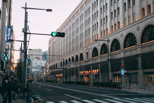 青信号の車道と横断歩道を待つ通行人の街角風景