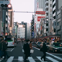赤信号と横断歩道を渡る通行人たちの写真