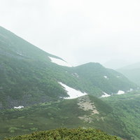 霧に包まれた乗鞍新登山道から見える山々と登山道の写真