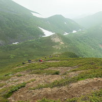 乗鞍新登山道のジグザグの登山道を下山する登山者の写真