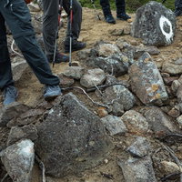 乗鞍新登山道の岩場で休憩する登山者たちの足元の写真