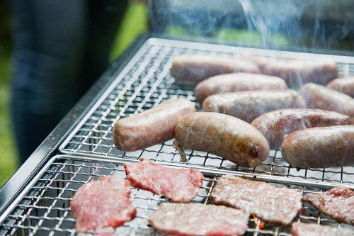 炭火で焼くソーセージと焼肉のバーベキュー