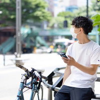 夏日にフードデリバリーで出かける自転車の男性の写真