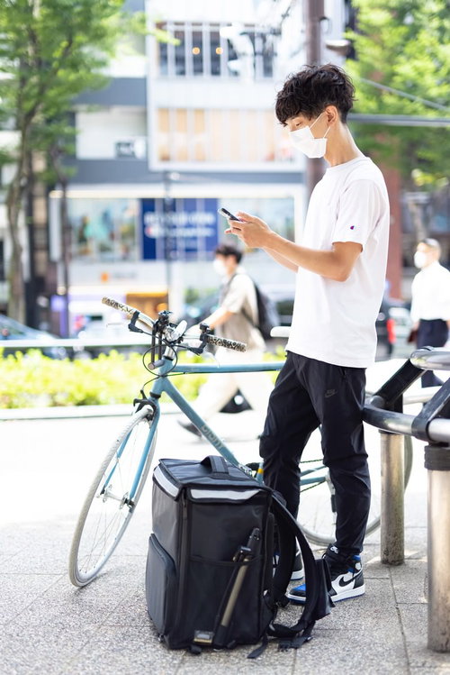 住所不明で顧客に連絡を入れる配達パートナーの男性