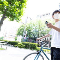 スマホのマップを見ながら配達先を検索する男性の写真