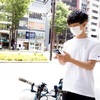 フードデリバリーアプリで周辺をスキャンする配達パートナー男性の写真